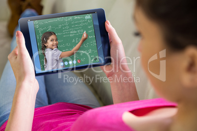 Composite image of woman using tablet at home