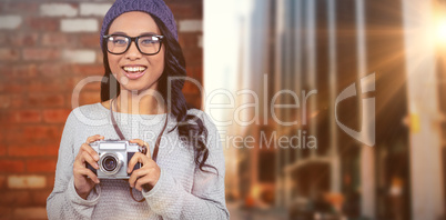 Composite image of asian woman holding digital camera