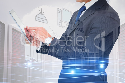 Composite image of businessman in suit using digital tablet