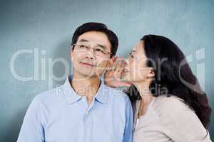 Composite image of woman whispering into partners ear