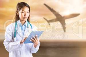 Composite image of asian doctor using tablet