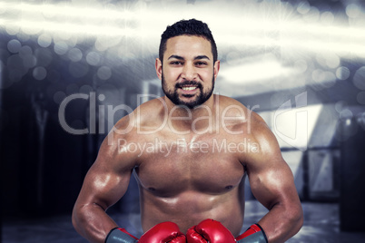 Composite image of muscular man boxing in gloves