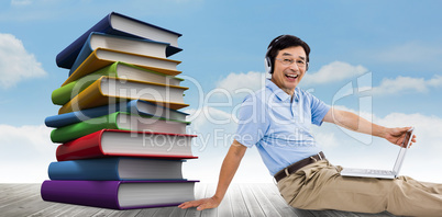 Composite image of portrait of cheerful man using laptop while l