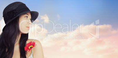 Composite image of cheerful woman with flower looking away weari
