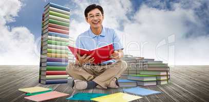 Composite image of smiling man reading books
