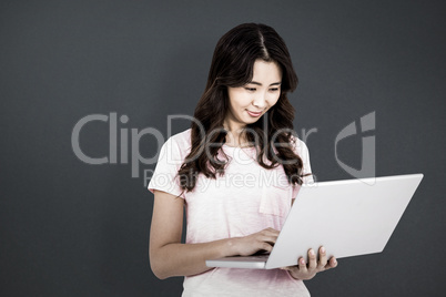 Composite image of happy woman using laptop