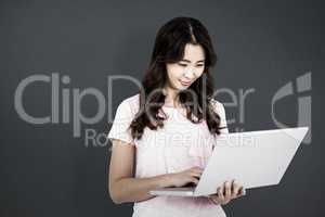 Composite image of happy woman using laptop