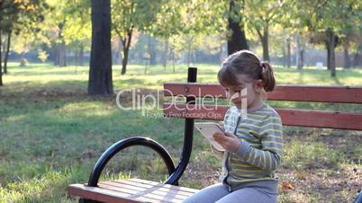 little girl play with tablet pc in park
