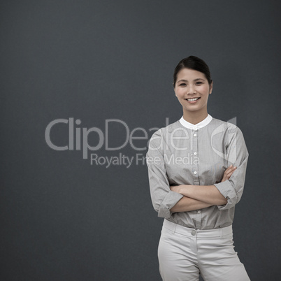 Composite image of selfassured businesswoman with folded arms