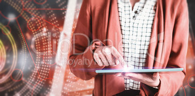 Composite image of businesswoman using a tablet