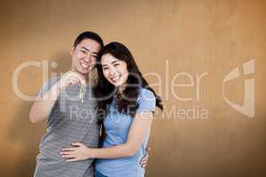 Composite image of portrait of happy young couple with keys