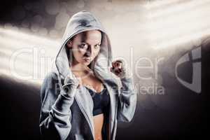 Composite image of portrait of female boxer in hood with fightin