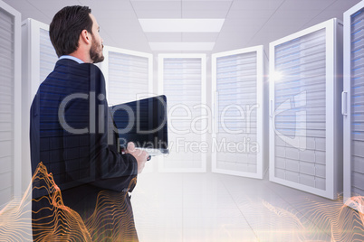 Composite image of businessman in suit holding laptop