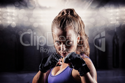 Composite image of portrait of woman with fighting stance