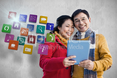 Composite image of asian couple on balcony using tablet