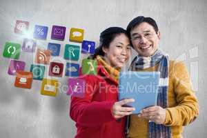Composite image of asian couple on balcony using tablet