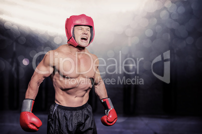Composite image of angry boxer against black background