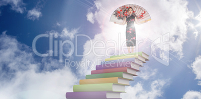 Composite image of woman wearing kimono with large fan