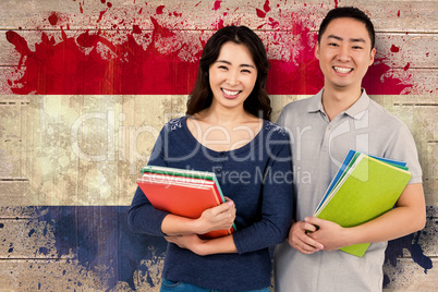 Composite image of happy couple holding books