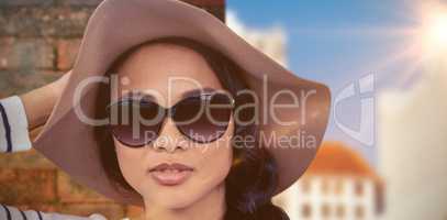 Composite image of attractive asian woman with hat and sunglasse