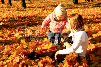 little sisters play with their cat in the autumn park