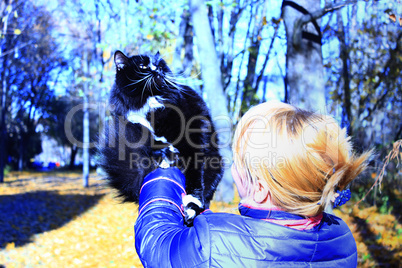 woman with black cat in the autumn park