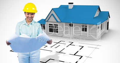 Composite image of architect reading a plan with yellow helmet