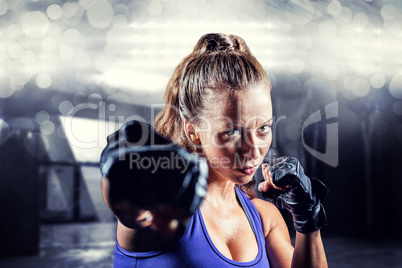 Composite image of portrait of female fighter punching