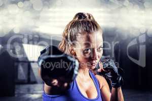 Composite image of portrait of female fighter punching