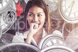 Composite image of businesswoman biting her fist