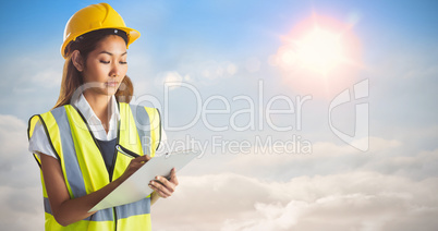 Composite image of architect woman with yellow helmet and plans
