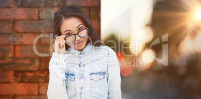 Composite image of asian woman holding eyeglasses
