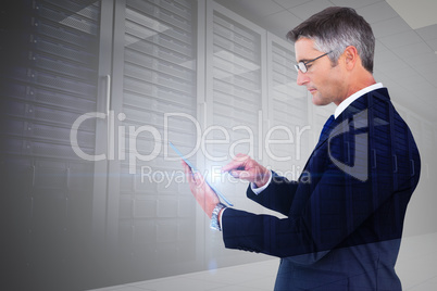 Composite image of mid section of a businessman touching tablet