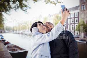 Composite image of cute couple taking selfie
