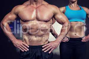 Composite image of midsection of muscular man and woman standing