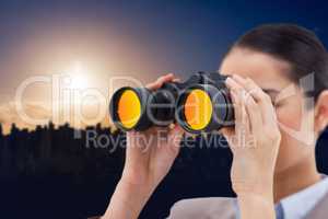 Composite image of brunette businesswoman looking through binocu
