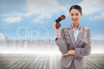 Composite image of portrait of a businesswoman holding binocular