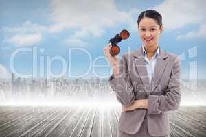 Composite image of portrait of a businesswoman holding binocular