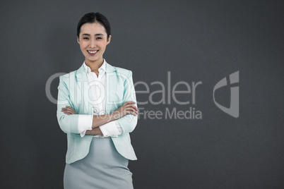 Composite image of elegant businesswoman with crossed arms