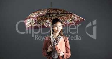 Composite image of businesswoman with an umbrella holding a bind