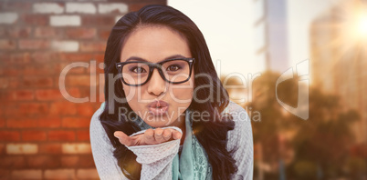 Composite image of asian woman blowing kiss to the camera