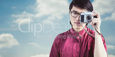 Composite image of hipster taking pictures with an old camera