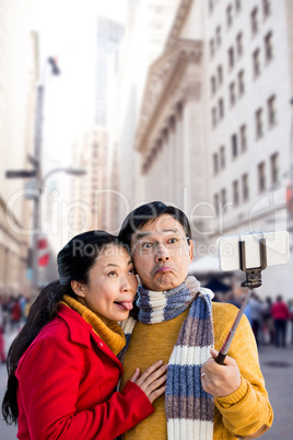 Composite image of older asian couple on balcony taking selfie