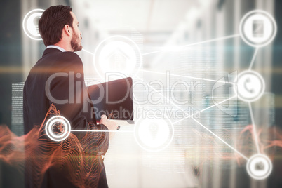 Composite image of businessman in suit holding laptop