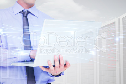 Composite image of businessman using a laptop