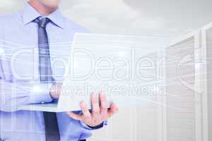 Composite image of businessman using a laptop