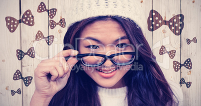Composite image of smiling asian woman holding eyeglasses
