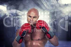 Composite image of portrait of bald boxer in red gloves