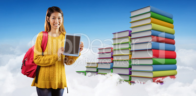 Composite image of smiling asian female student showing tablet