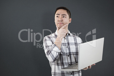 Composite image of thoughtful man holding laptop